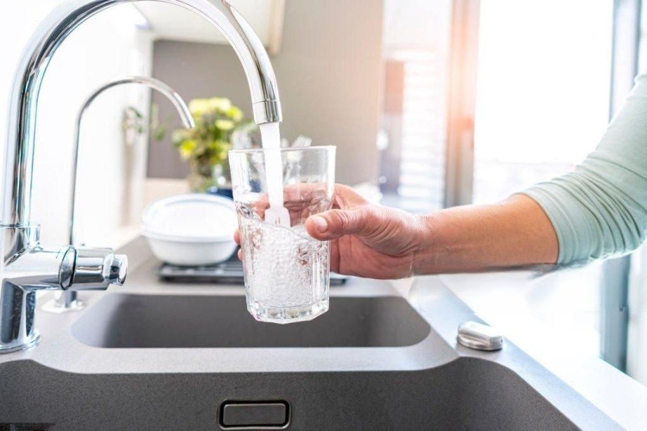 Drinking Water RO System A person filling a glass with water from the tap